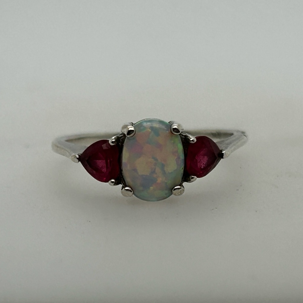 Vintage inspired three stone ring. Main stone is an oval opal